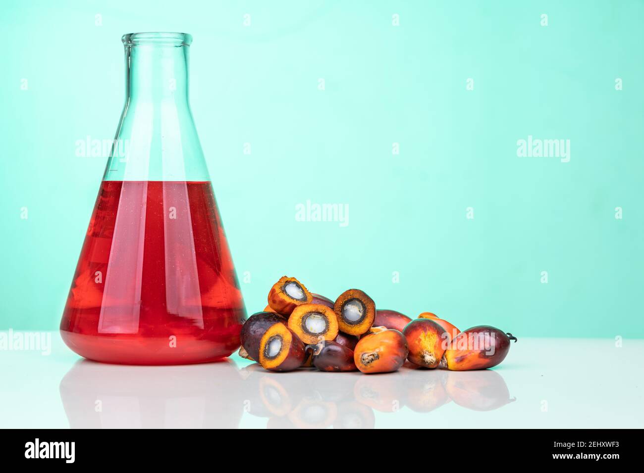 Red color unrefined palm oil and fruits with beaker in laboratory Stock Photo