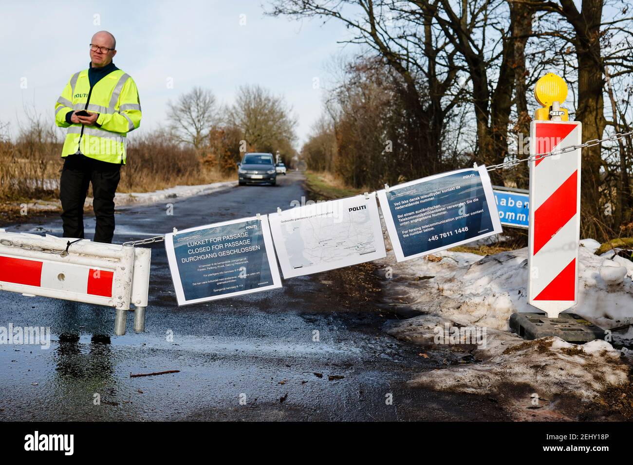Handewitt, Germany. 20th Feb, 2021. A Danish police officer stands at a closed border crossing