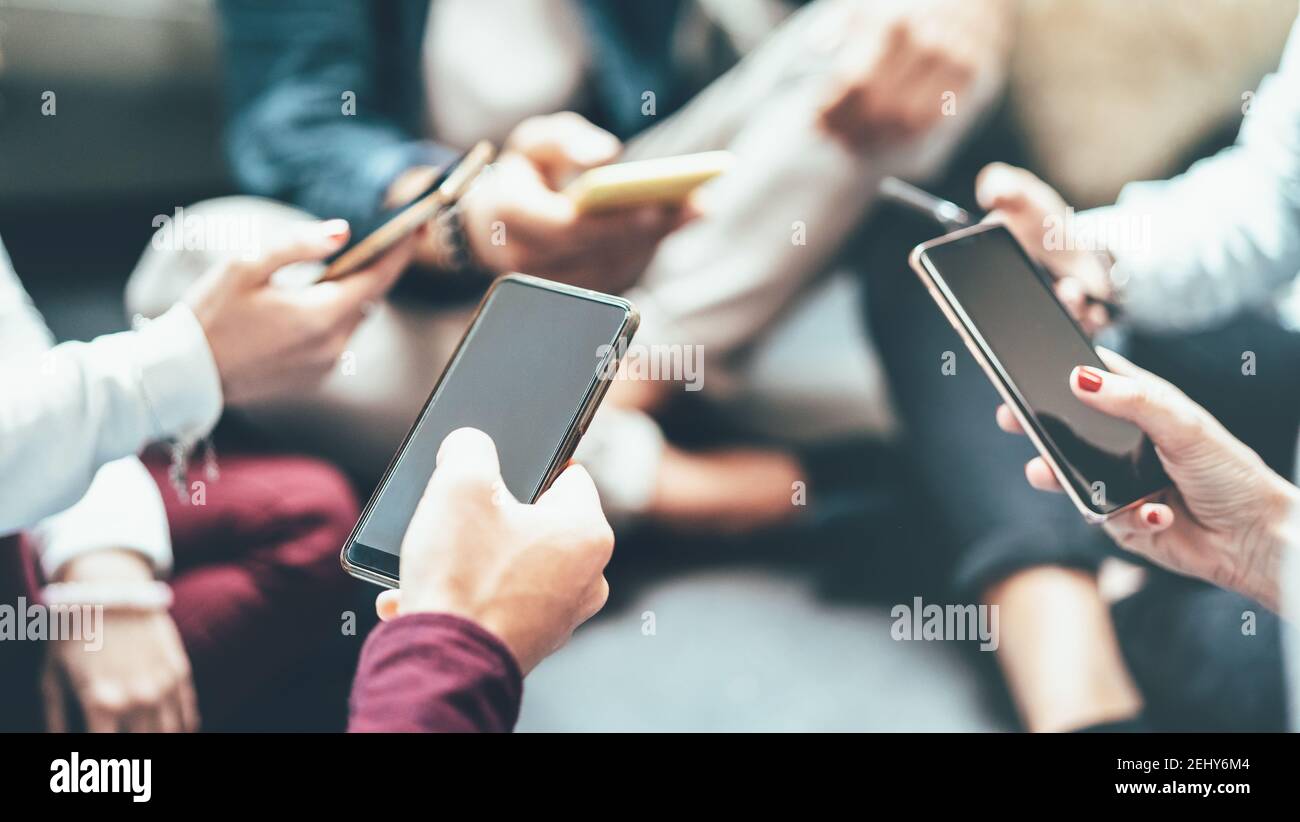 Friends group having addicted fun using mobile smart phone - Close up of people hands sharing content on social media network with smartphone Stock Photo