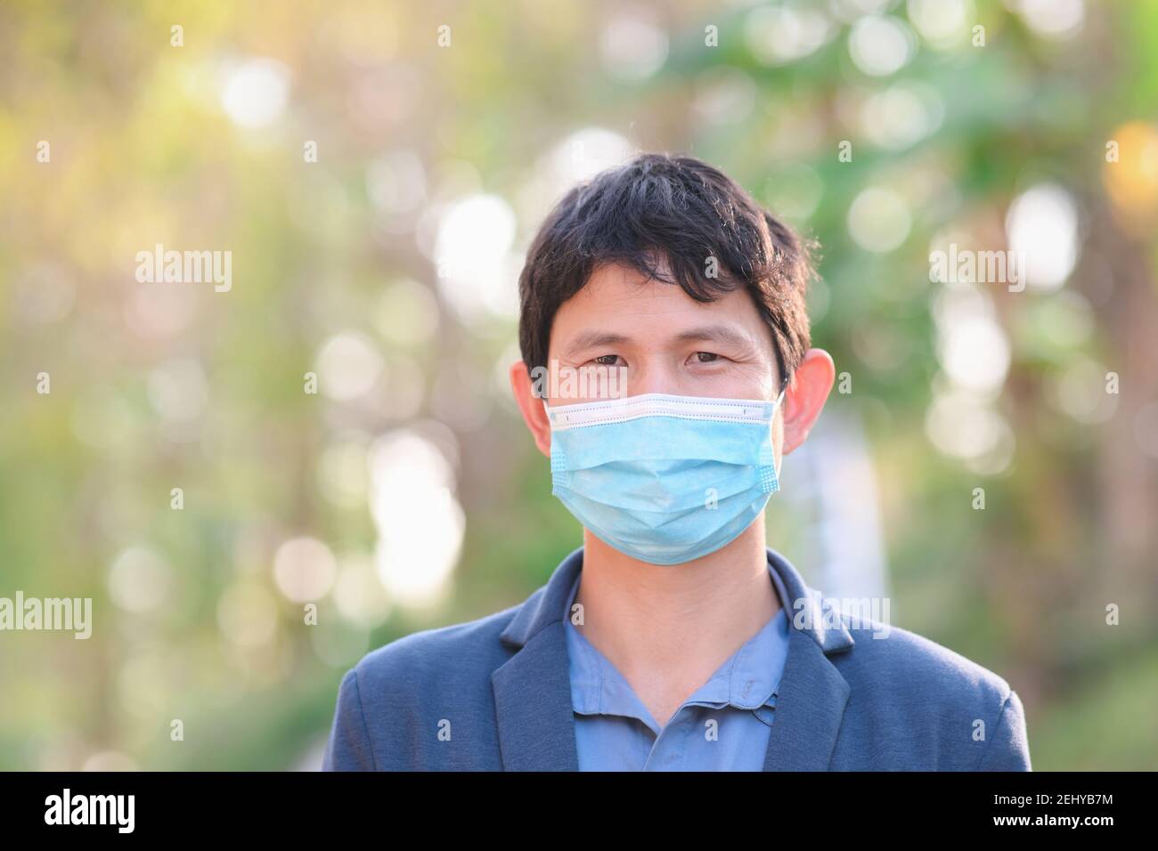 Man wearing a cloth mask in public area protect himself from risk of disease, people prevent infection from coronavirus Covid-19 or Air pollution Stock Photo