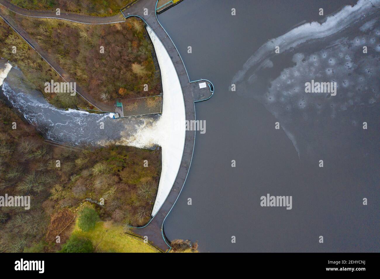 Glen Devon, Perth and Kinross, Scotland, UK. 20 Feb 2021. Meltwater from recent snow and heavy rain has filled Scottish reservoirs to capacity. Dam spillways are now full whilst discharging water downstream. Pic; Drone image of spillway at Castlehill Dam running at full capacity to discharge water from the reservoir. Iain Masterton/Alamy Live News Stock Photo