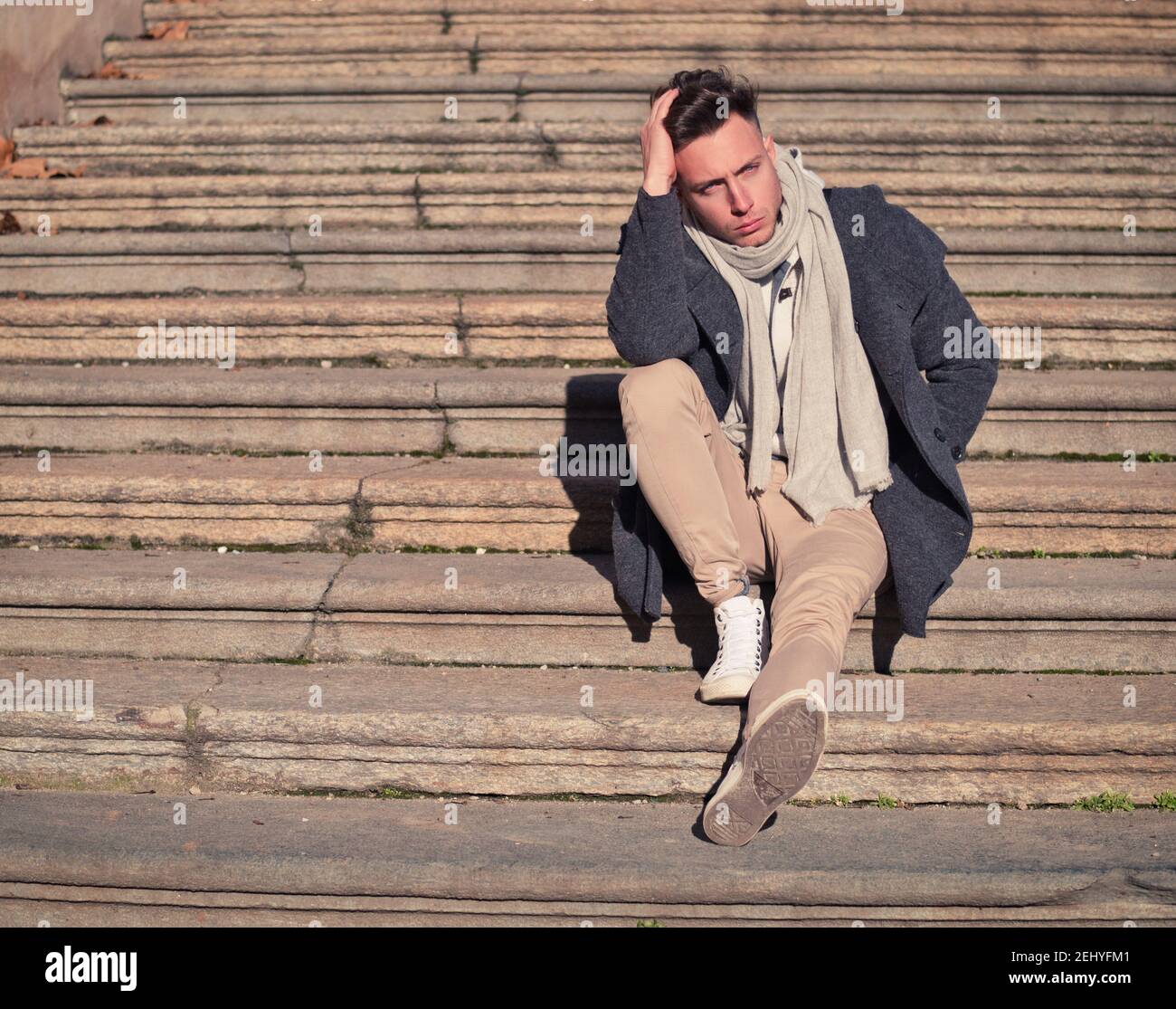 Handsome young man outdoor sitting on stone stairs outside Stock Photo ...