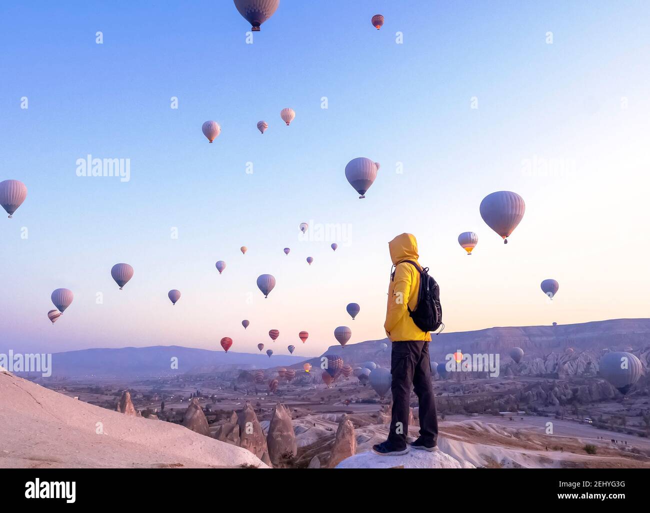 A tourist with a backpack see on soaring hot air balloons in Cappadocia, Turkey, concept achievement, team, leader. Stock Photo