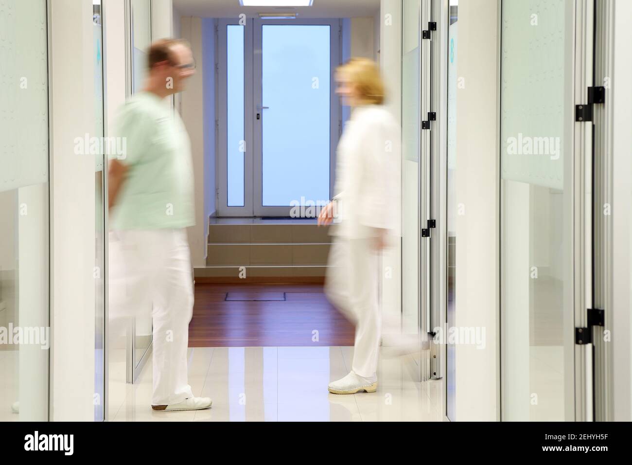 Two Blurry Doctors in a Clinic Passing Each Other Stock Photo