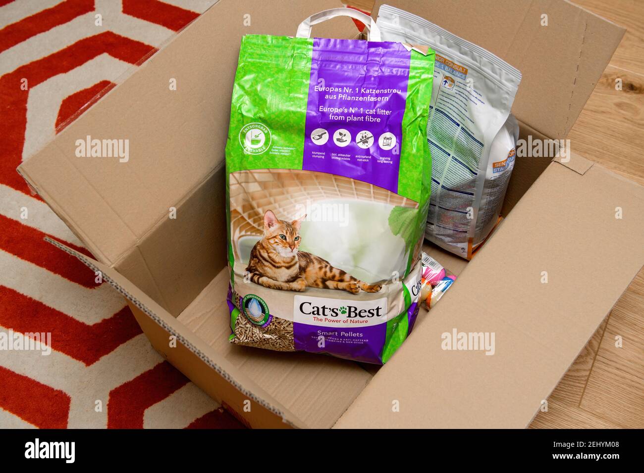 Strasbourg, France - Jan 16, 2021: Overhead view of Living room carpet with cardboard box delivery containing Cats Best litter wood bio organic and Royal Canin Senior Consult stage cat's food Stock Photo