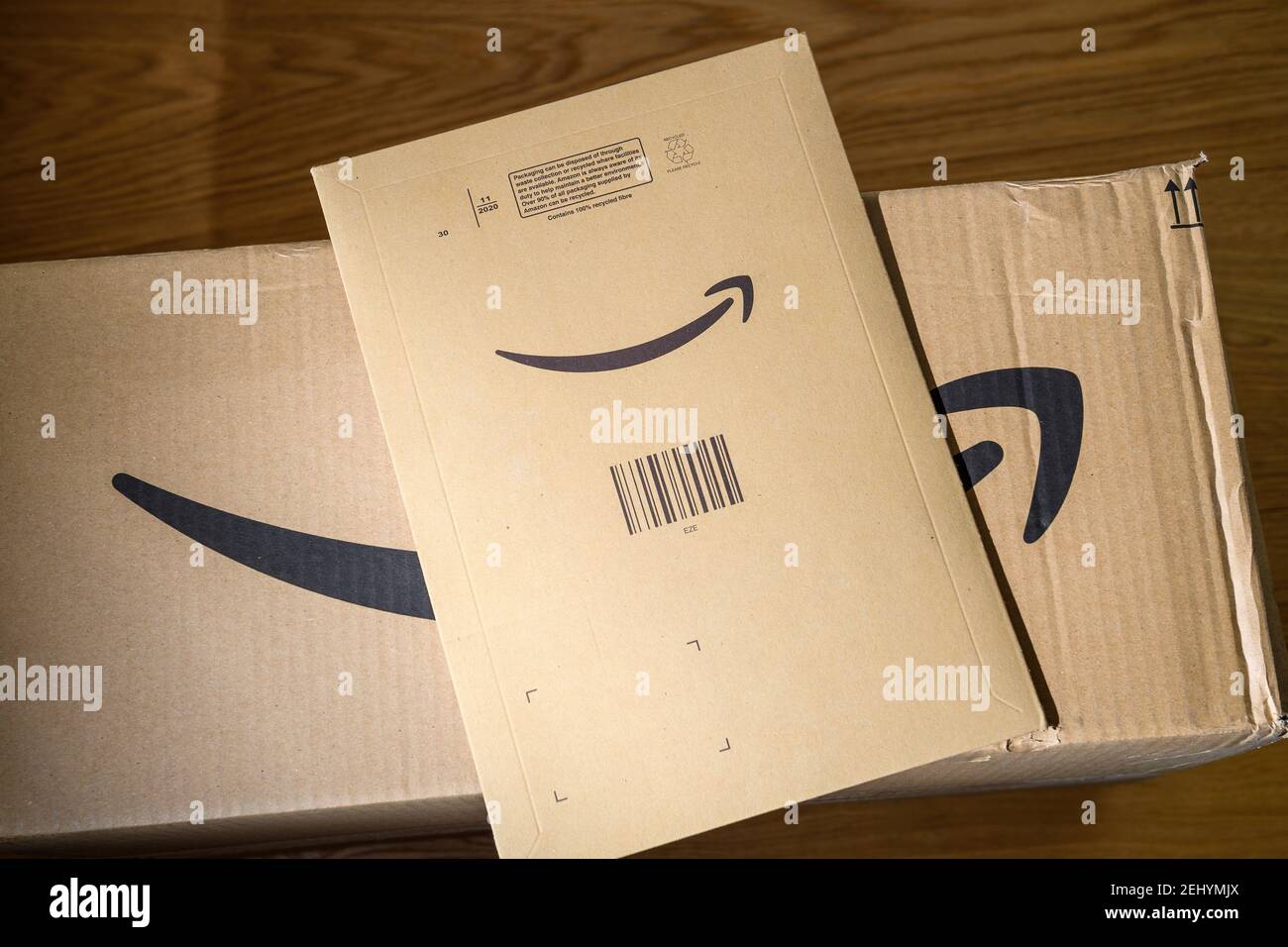 Paris, France - FEb 6, 2021: Two Amazon Prime cardboard parcels one large box and one envelope with multiple objects inside. Amazon.com was founded by Jeff Bezos Stock Photo