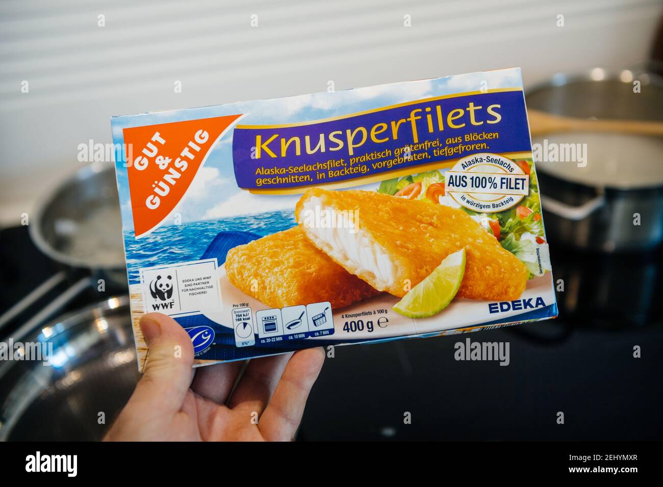Paris, France - FEb 13, 2021: POV male hand holding new pack with frozen fish from Edeka Gut und Gunstig traditional knusperfilets - kitchen background Stock Photo