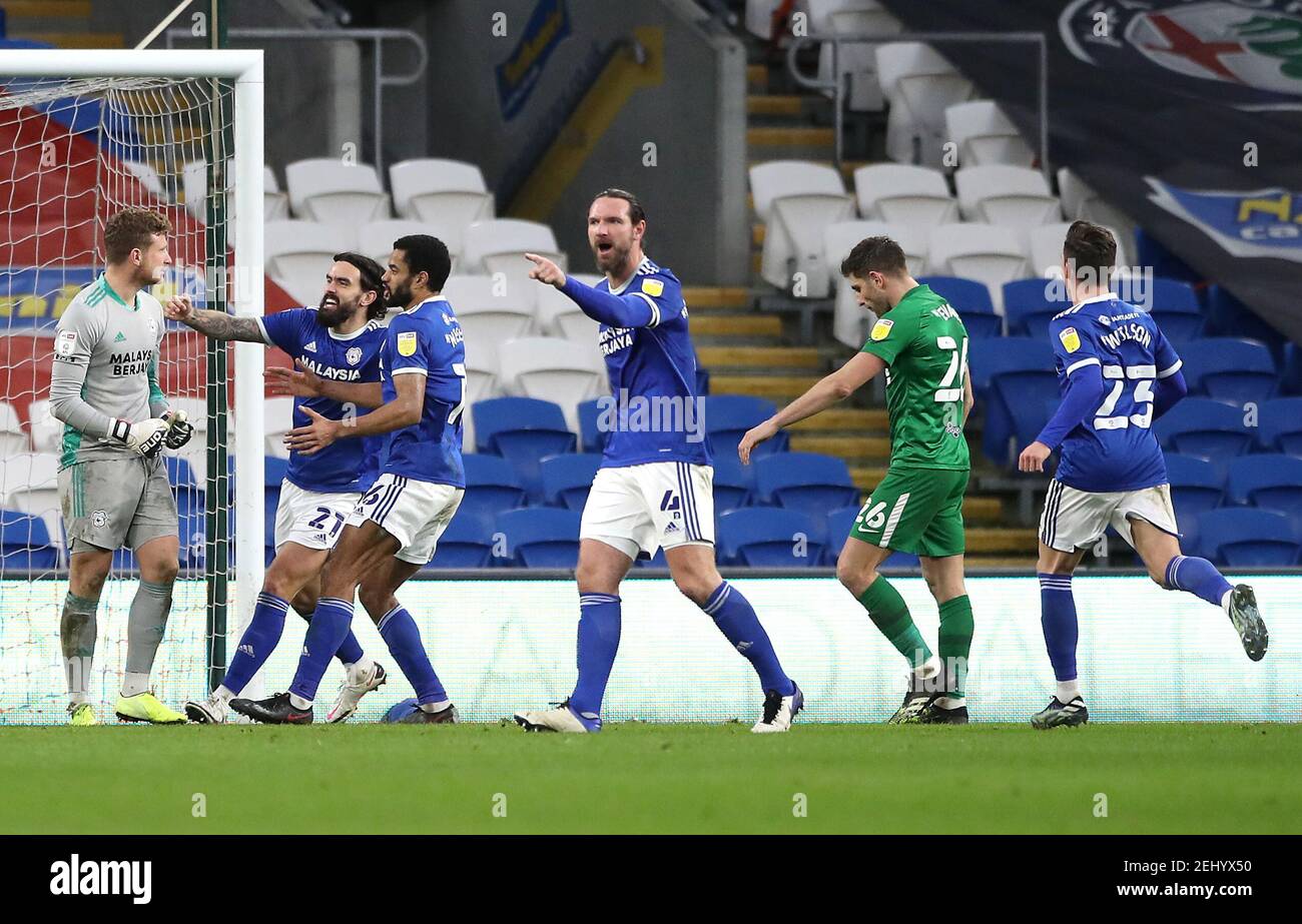 Preston North End's Ched Evans (second right) reacts after missing his side's second penalty kick as Cardiff City's Dillon Phillips (left) celebrates during the Sky Bet Championship match at Cardiff City Stadium, Cardiff. Picture date: Saturday February 20, 2021. Stock Photo