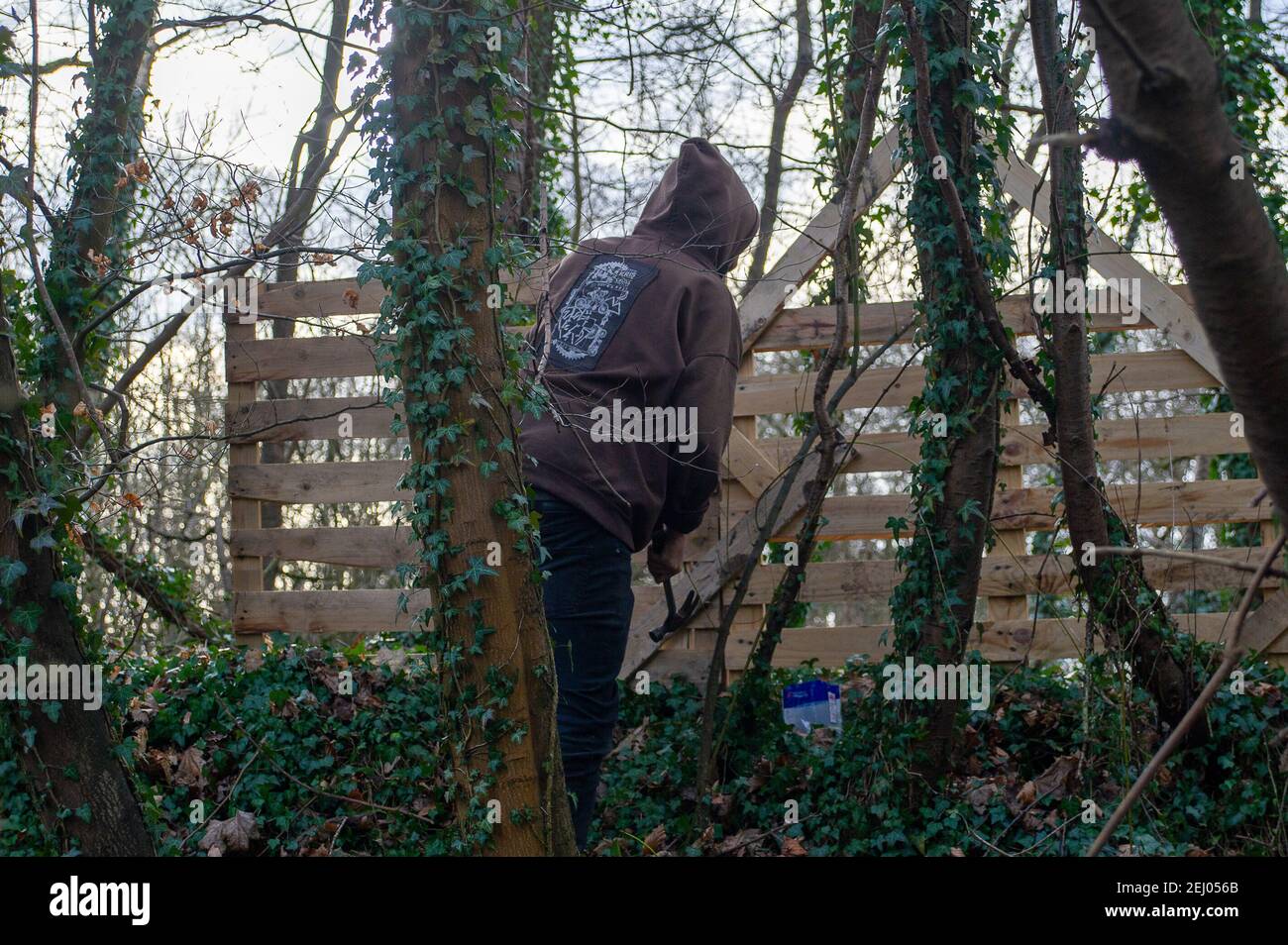 Aylesbury, Buckinghamshire, UK. 20th February, 2021. Stop HS2 activists are putting up more pallets around their camp as they try to protect HS2 from felling more trees. HS2 Ltd took over a wood called the Spinney earlier this week and have started to destroy it. Stop HS2 activists have set up a new camp in the woodlands near it in an attempt to stop HS2 from felling the trees. The number of protesters is growing by the day as people get to see just how destructive the High Speed Rail from London to Birmingham is to the environment. Credit: Maureen McLean/Alamy Live News Stock Photo