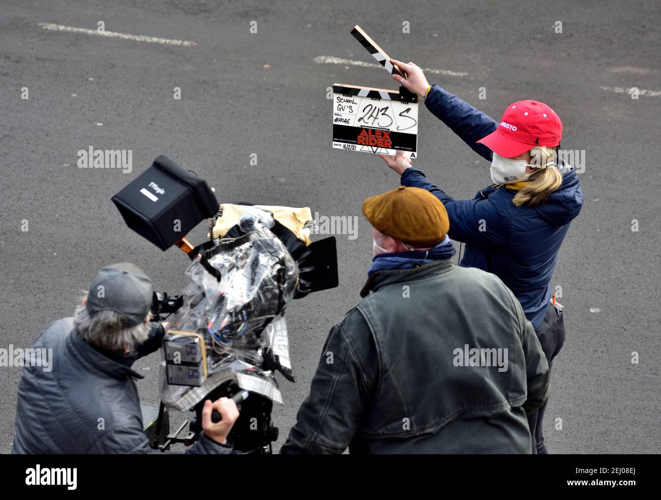 Clapper board being used to start a new shoot on location filming of Alex Rider story, cameraman on crane platform Stock Photo