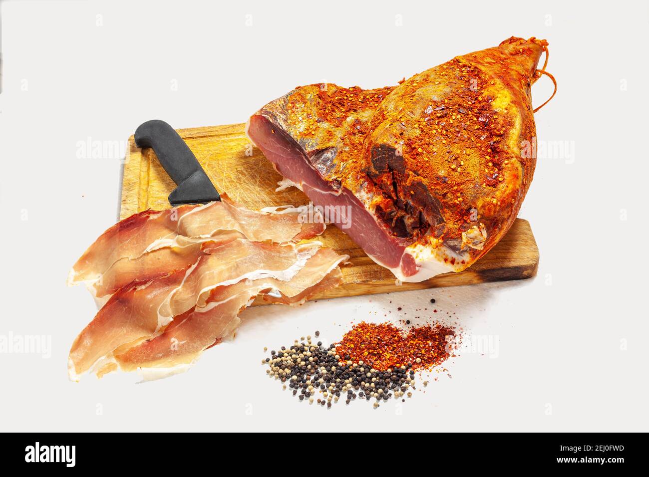 boneless ham, with red pepper and black pepper, cut into slices. On white background. Stock Photo