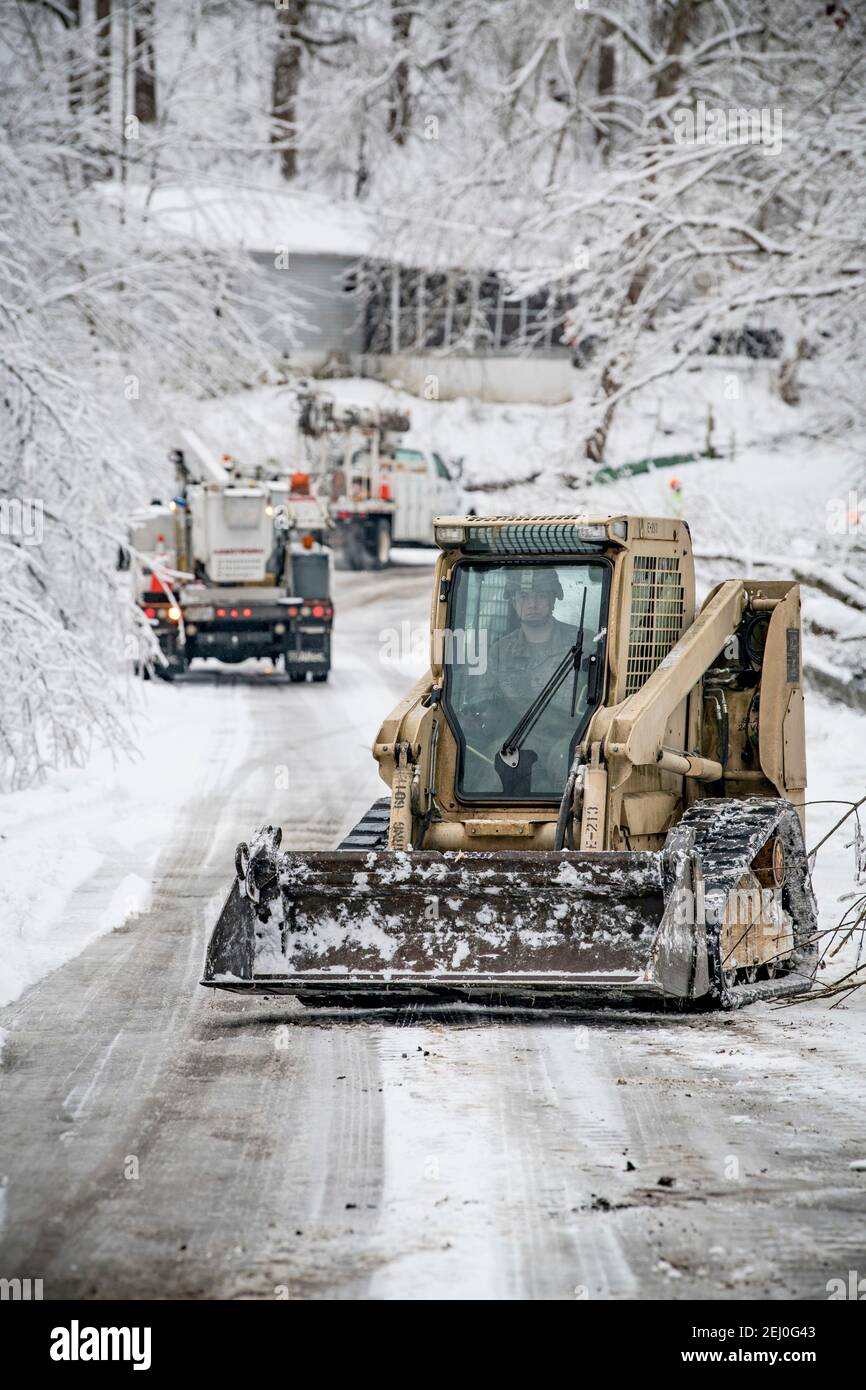 Ceredo, United States. 19th Feb, 2021. U.S. soldiers with the West Virginia National Guard clear debris from a winter storm off a road February 19, 2021 in Ceredo, Wayne County, West Virginia. A large winter storm system earlier in the week left more than 90,000 West Virginians without electric throughout the region, felling trees and making remote roads impassable. Credit: Planetpix/Alamy Live News Stock Photo