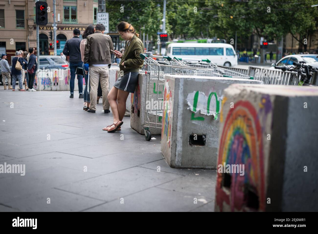 A young woman checks her phone outside Flinders Street Station, Melbourne, Victoria, Australia. Stock Photo