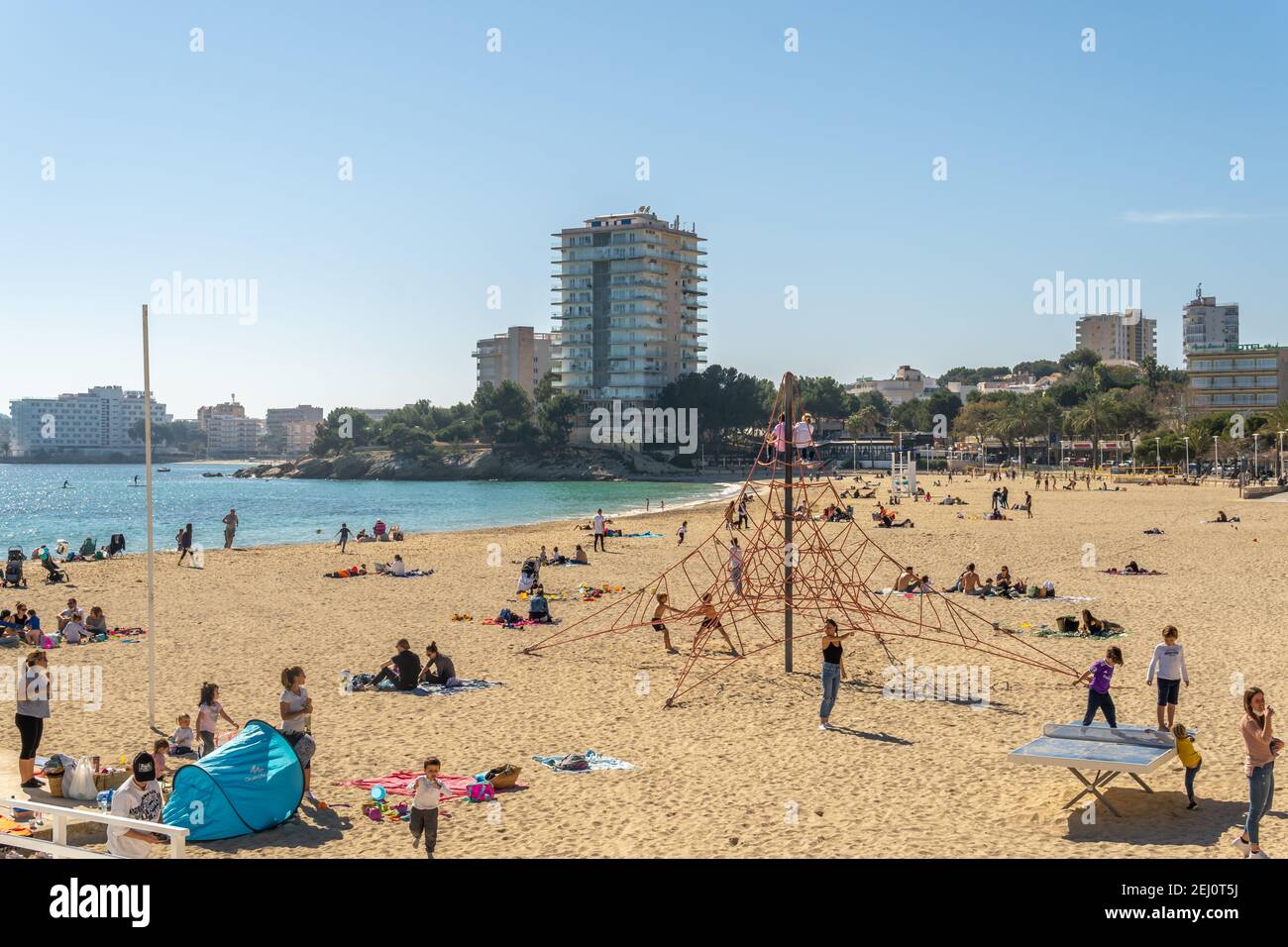 Palmanova, Spain; february 20 2021: general view of the marina and beach of the Mallorcan resort of Palmanova on a sunny day, with families enjoying t Stock Photo