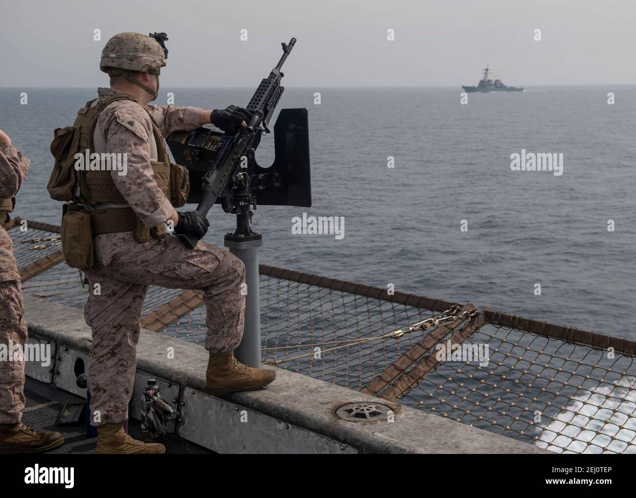 A U.S. Marine with the 15th Marine Expeditionary Unit, stands security watch aboard the U.S. Navy San Antonio-class amphibious transport dock ship USS San Diego, as they transit the Strait of Hormuz February 19, 2021 off the coast of Oman. Stock Photo