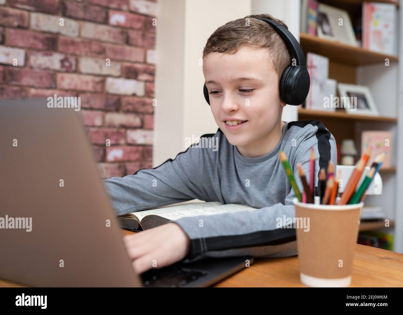 Boy using computer with headphones hires stock photography and images