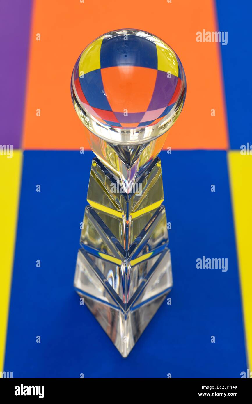 Glass ball on top of a crystal pedestal with refraction of colorful tiles Stock Photo