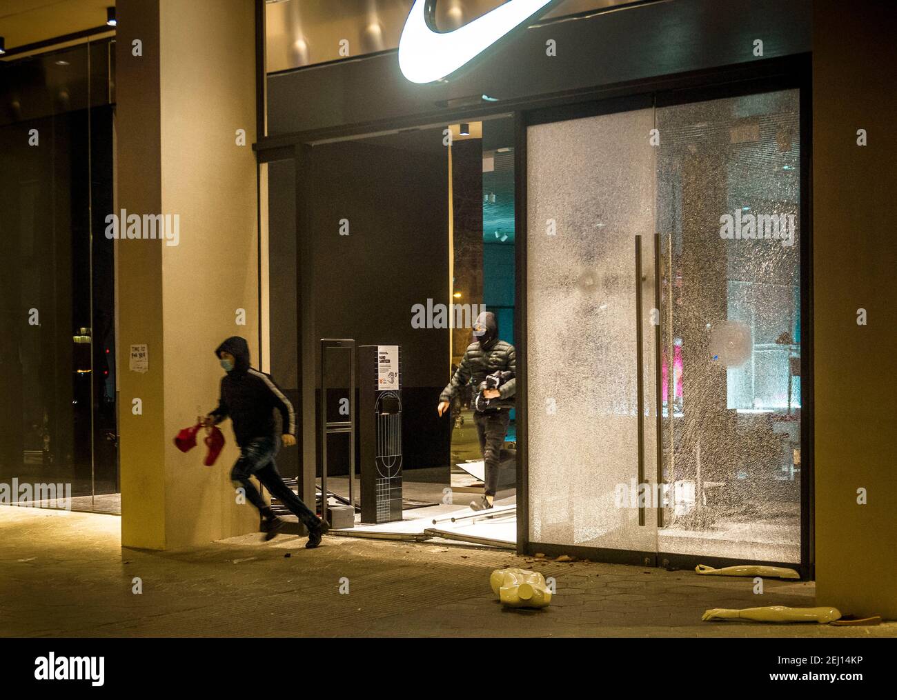 Barcelona, Spain. 20th Feb, 2021. Looters run out of a Nike store in  Barcelona's center as a protest following the imprisonment of rapper 'Pablo  Hasel', convicted to jail for glorifying terrorism and