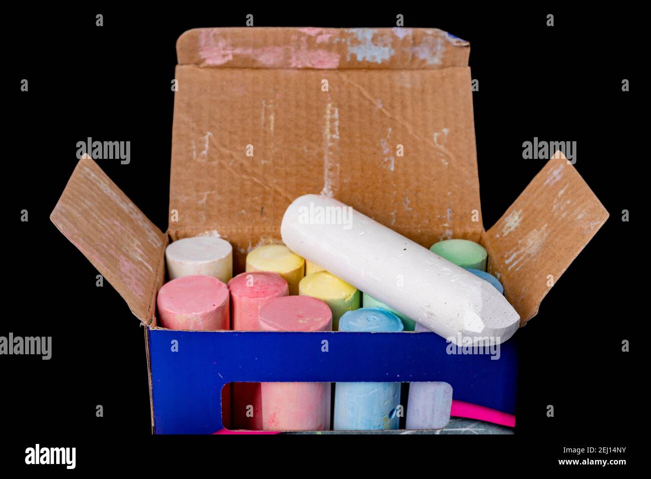 A box of colored chalk for street drawing. School chalk in a cardboard box. Dark background. Stock Photo