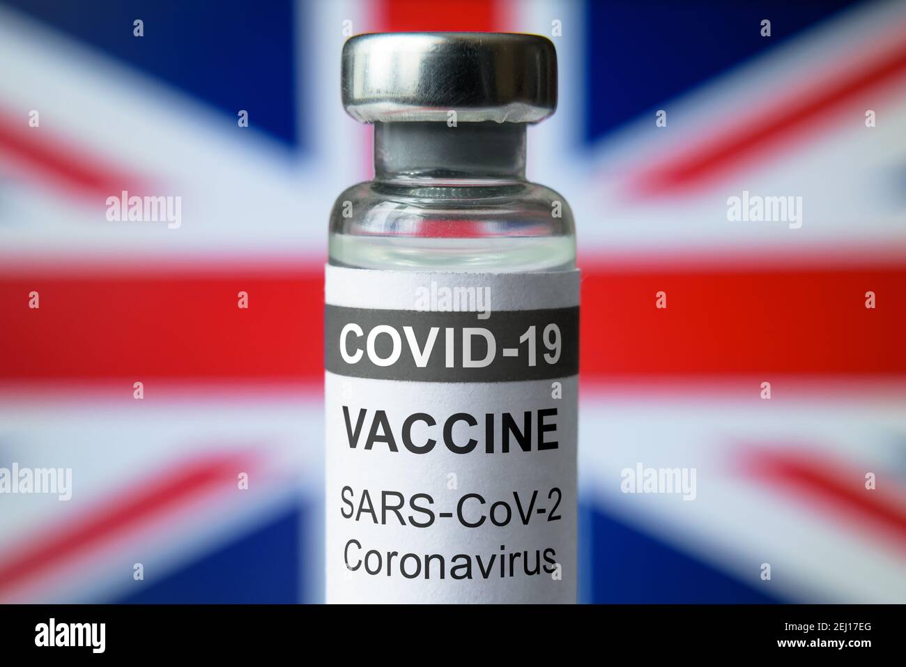 COVID-19 vaccine on UK flag background, bottle with British vaccine for coronavirus close-up. Concept of treatment, clinical trial, distribution and r Stock Photo