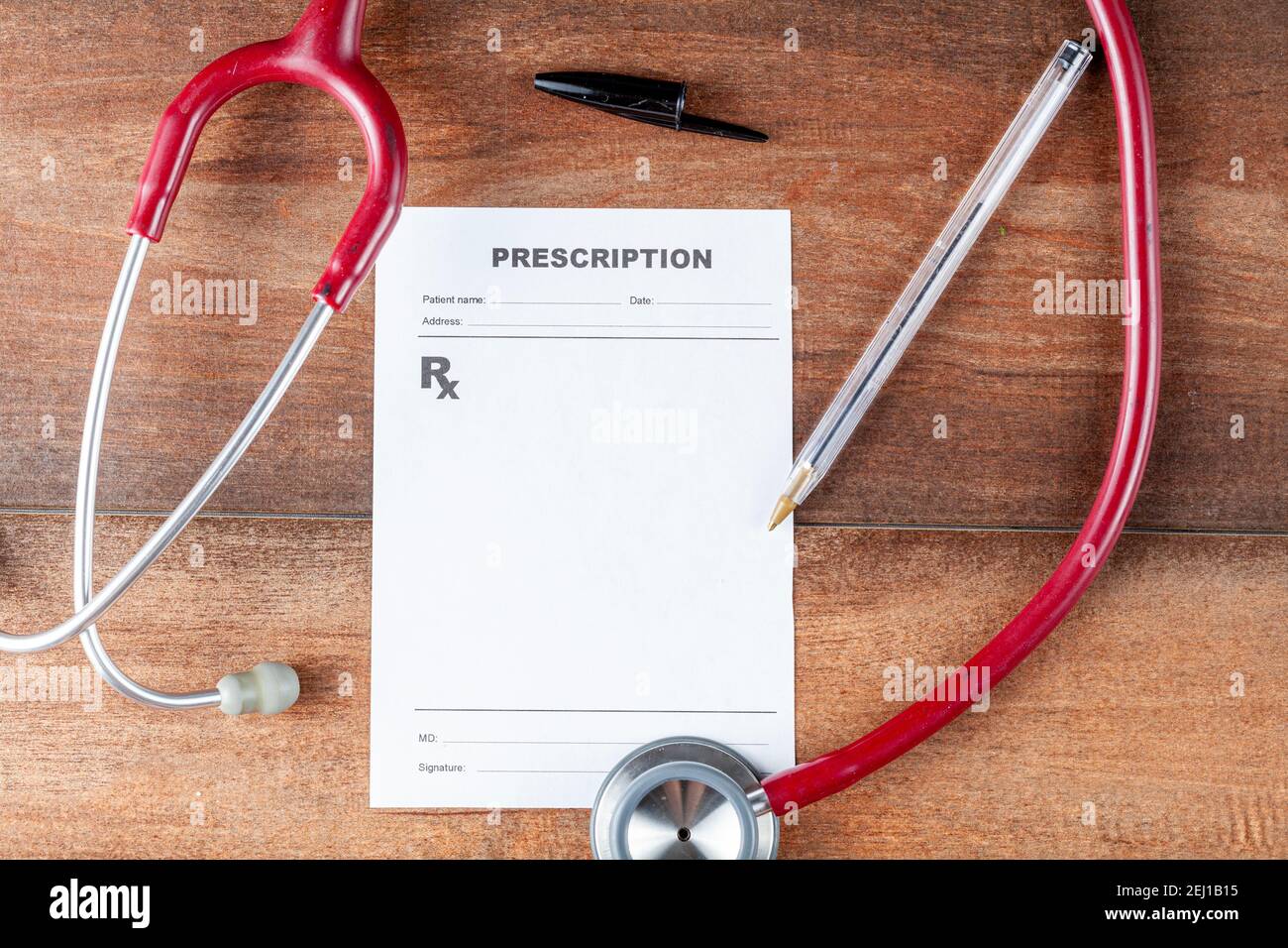 close up isolated flat lay image of a physician's desk where there is a pen, sthetoscope and a blank prescription which can be used as template to add Stock Photo