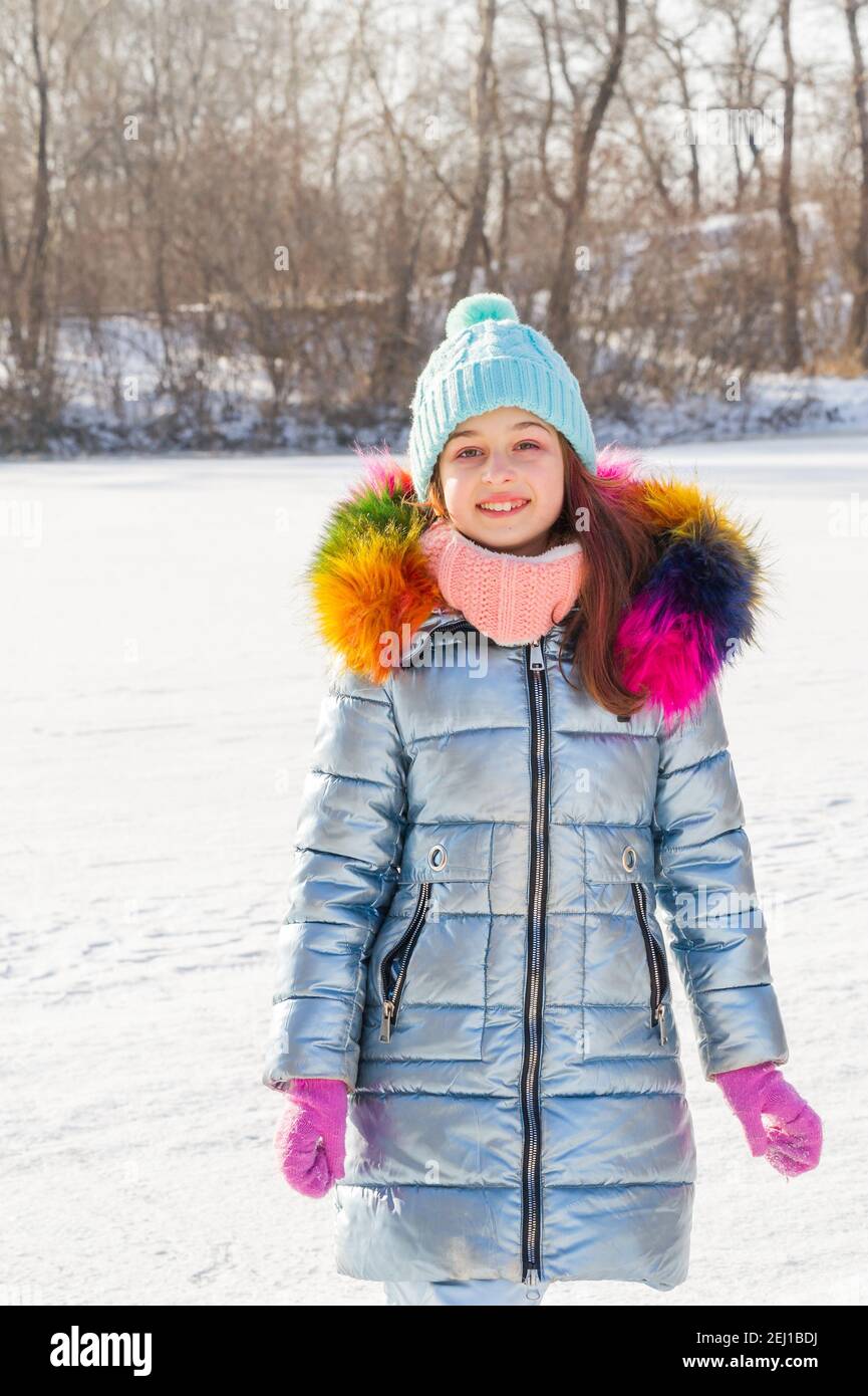 girl in a hat and a blue jacket. School child in winter clothes on the