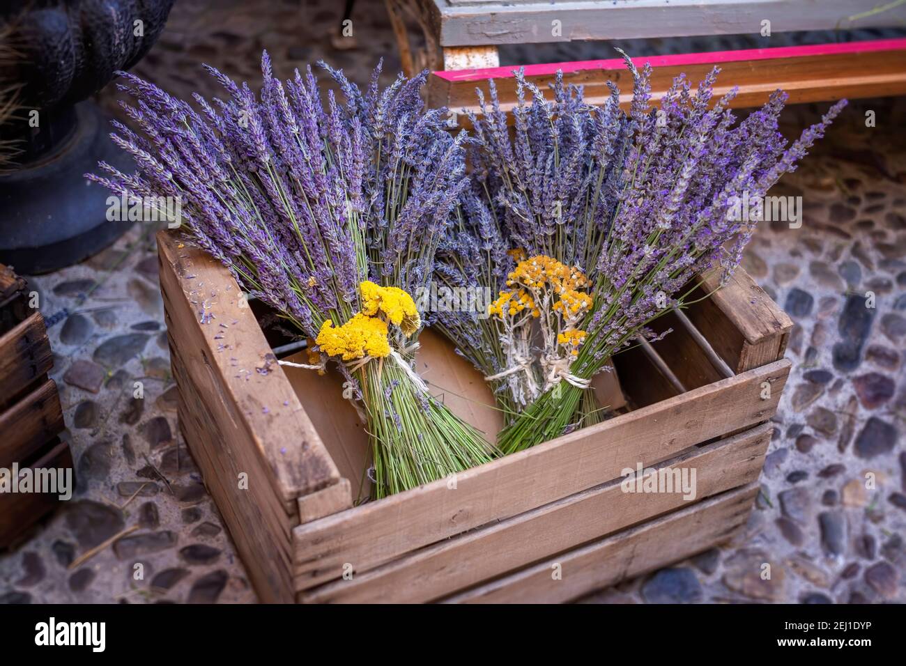 lavender bouquets decorated with yellow flowers of Helichrysum stoechas, inside a wooden box at a flower market in Brihuega, Guadalajara Spain Stock Photo