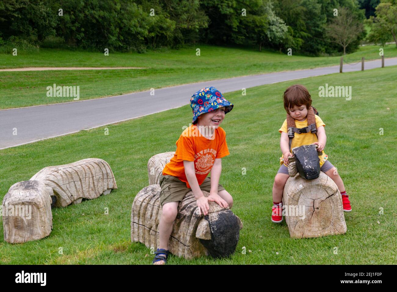 Children playing in a field with some wood animals Stock Photo