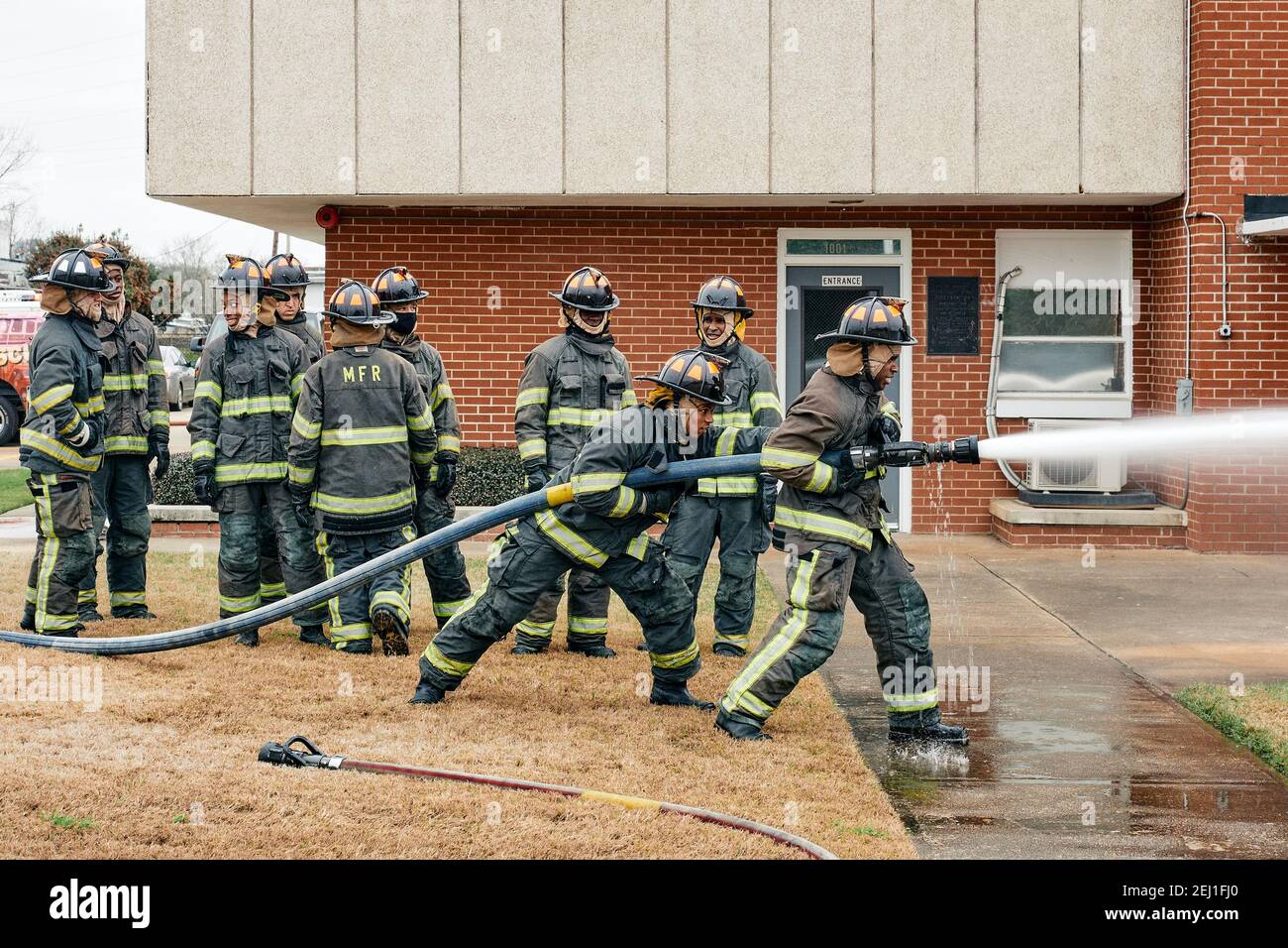 Firefighter trainees going through firefighter training with fire hoses at the fire academy in Montgomery Alabama, USA. Stock Photo