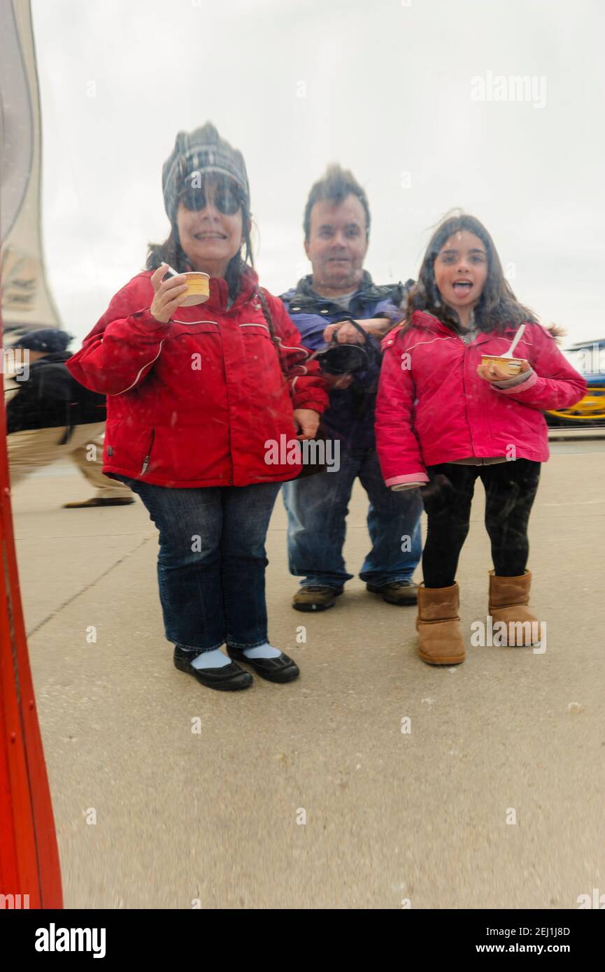 Funhouse mirror, the image of a family is reflected on the surface of a distorting mirror at Navy Pier, Chicago, Illinois. Stock Photo