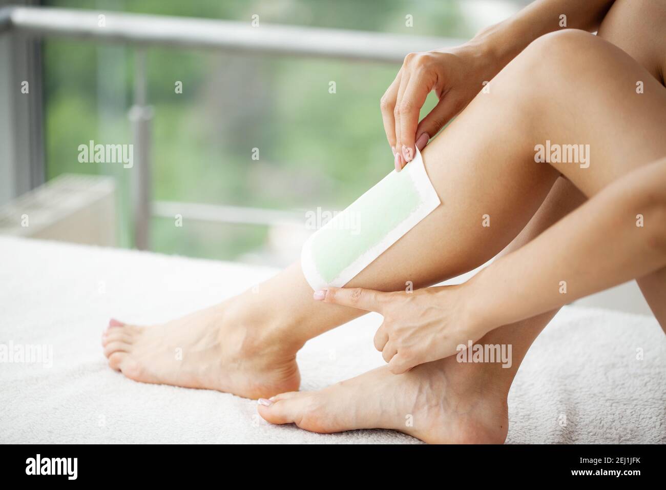 Woman uses wax tape to remove hair on legs Stock Photo - Alamy