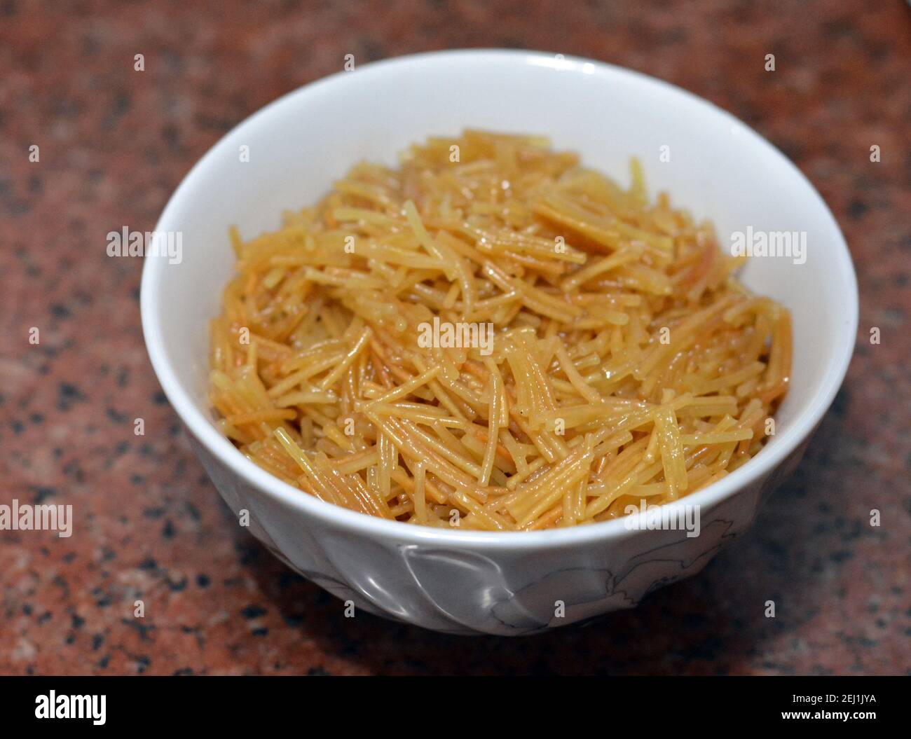 Browned in Butter sweet Egyptian vermicelli cooked with water and sugar served in a white dish,. traditional Egyptian dessert in late lunch and early Stock Photo