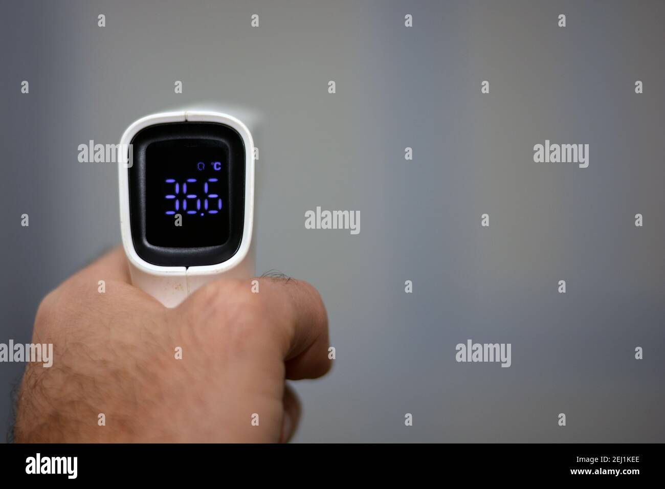 https://c8.alamy.com/comp/2EJ1KEE/non-contact-infrared-forehead-digital-thermometer-held-by-a-young-man-with-left-hand-with-a-defocused-background-close-up-view-2EJ1KEE.jpg