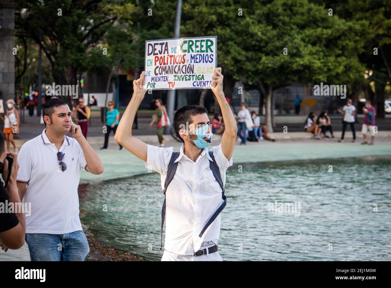 Coronavirus denier protests during a demonstration and in his cartel (in spanish) says to stop believing politicians and medias Stock Photo