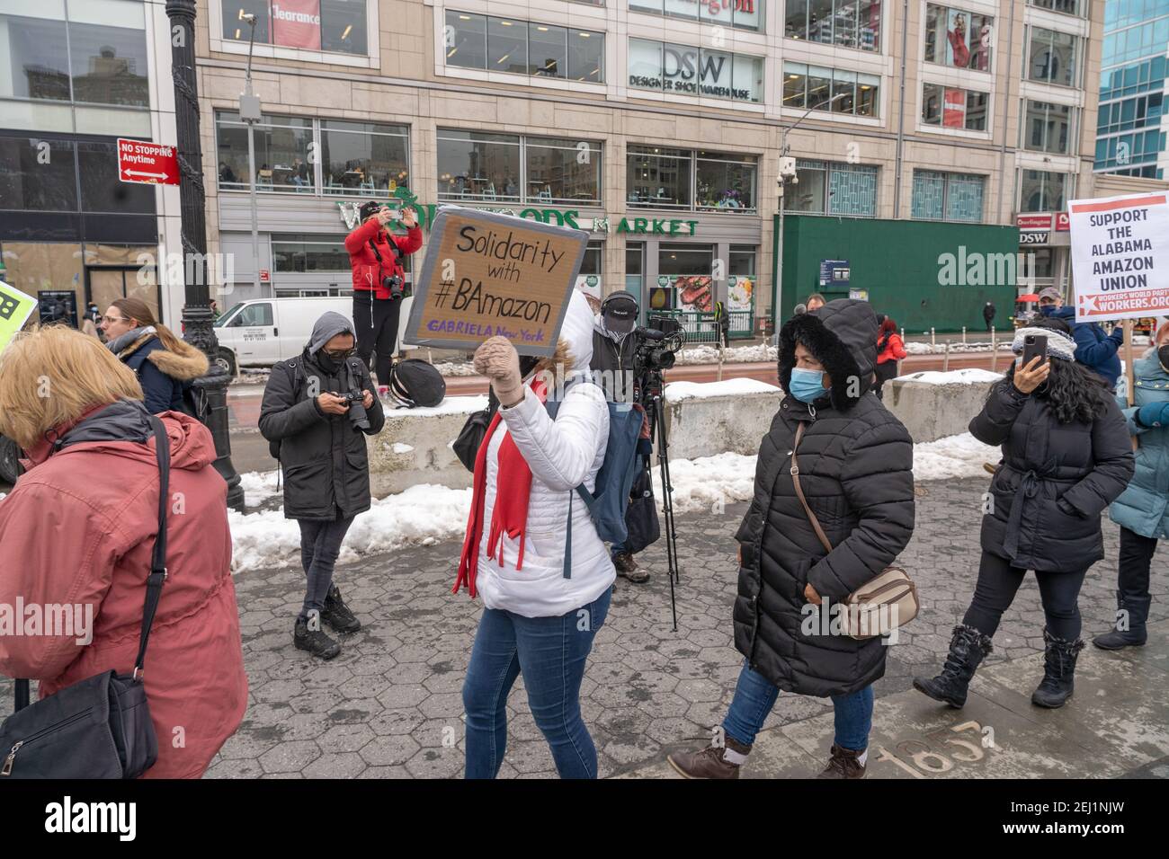 New York, USA. 20th Feb, 2021. Protestors holding signs picket across from Amazon's Union Square Whole Foods Market in support of Alabama Amazon Union on February 20, 2021 in New York City. The Southern Workers Assembly organized a National Day of Solidarity on February 20th, for anyone supporting workers' rights. Activists in New York City came out to show their support on Saturday for the approximately 6,000 Amazon warehouse workers in Bessemer, Alabama, who will vote by mail on whether to be represented by the Retail, Wholesale Department Store Workers Union (RWDSU). Credit: Ron Adar/Alamy  Stock Photo
