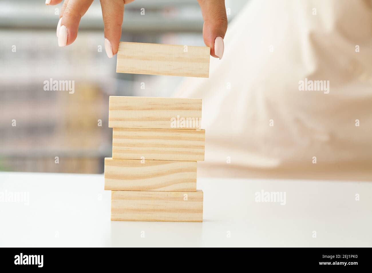 Hand putting and stacking blank wooden cubes on table with copy space ...