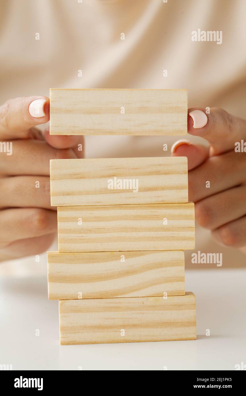 Hand putting and stacking blank wooden cubes on table with copy space ...