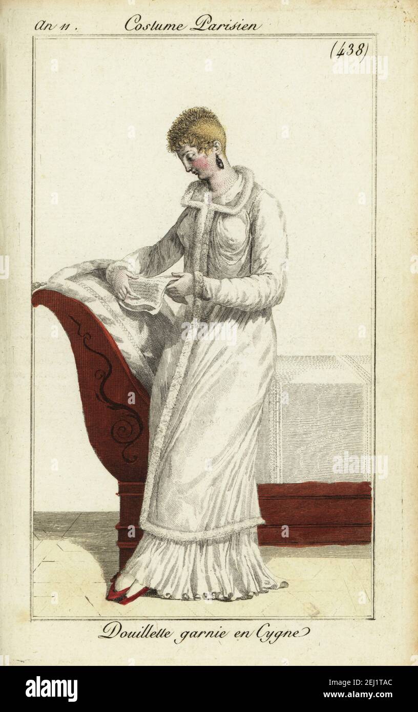 Woman with short hair a la Titus or a la Victime reading a letter. Loose  long housecoat or cosy decorated with swan's-down over a dress. She leans  on a Empire-style bed. Douillette