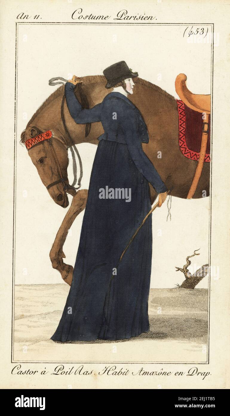 Woman rider or Amazone with her horse. She wears a short-haired beaver-skin hat, long riding dress in wool and holds a riding crop. Castor à Poil Ras. Habit Amazône en Drap. Handcoloured copperplate engraving from Pierre de la Mesangere’s Journal des Dames et des Modes, Magazine of Women and Fashion, Paris, An 11, 1803. Illustrations by Carle Vernet, Jean-Francois Bosio, Dominique Bosio and Philibert Louis Debucourt, engraved by Pierre-Charles Baquoy. Stock Photo