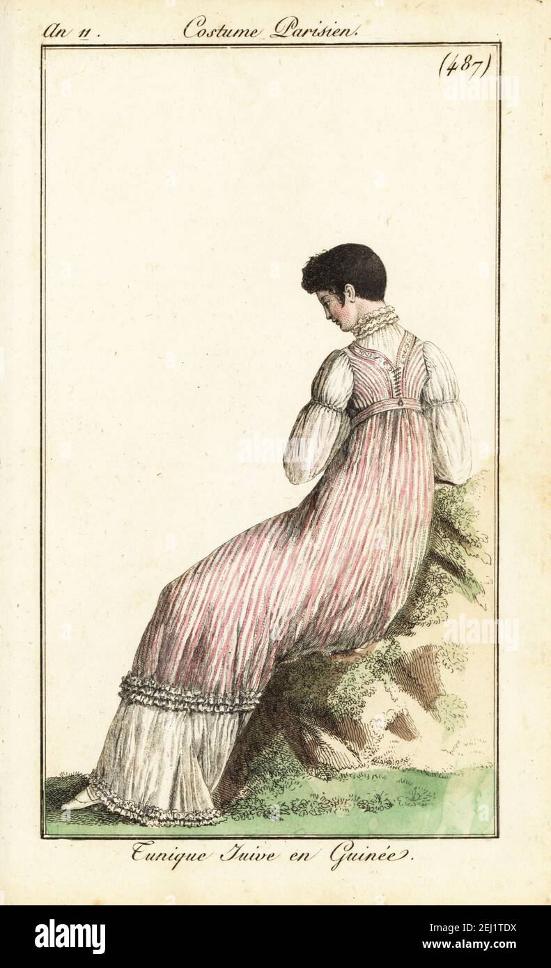 Fashionable woman with short hair a la Victime. She wears a calico tunic over a long gown. Tunique Juive en Guinée. Handcoloured copperplate engraving from Pierre de la Mesangere’s Journal des Dames et des Modes, Magazine of Women and Fashion, Paris, An 11, 1803. Illustrations by Carle Vernet, Jean-Francois Bosio, Dominique Bosio and Philibert Louis Debucourt, engraved by Pierre-Charles Baquoy. Stock Photo