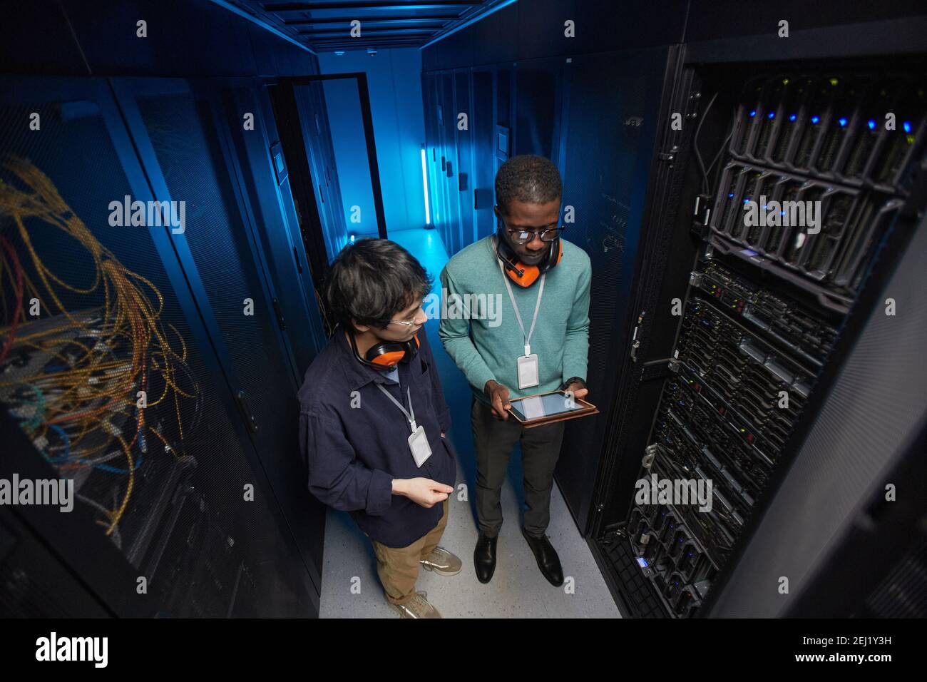 High angle view at two young technicians setting up server network while working in data center, copy space Stock Photo