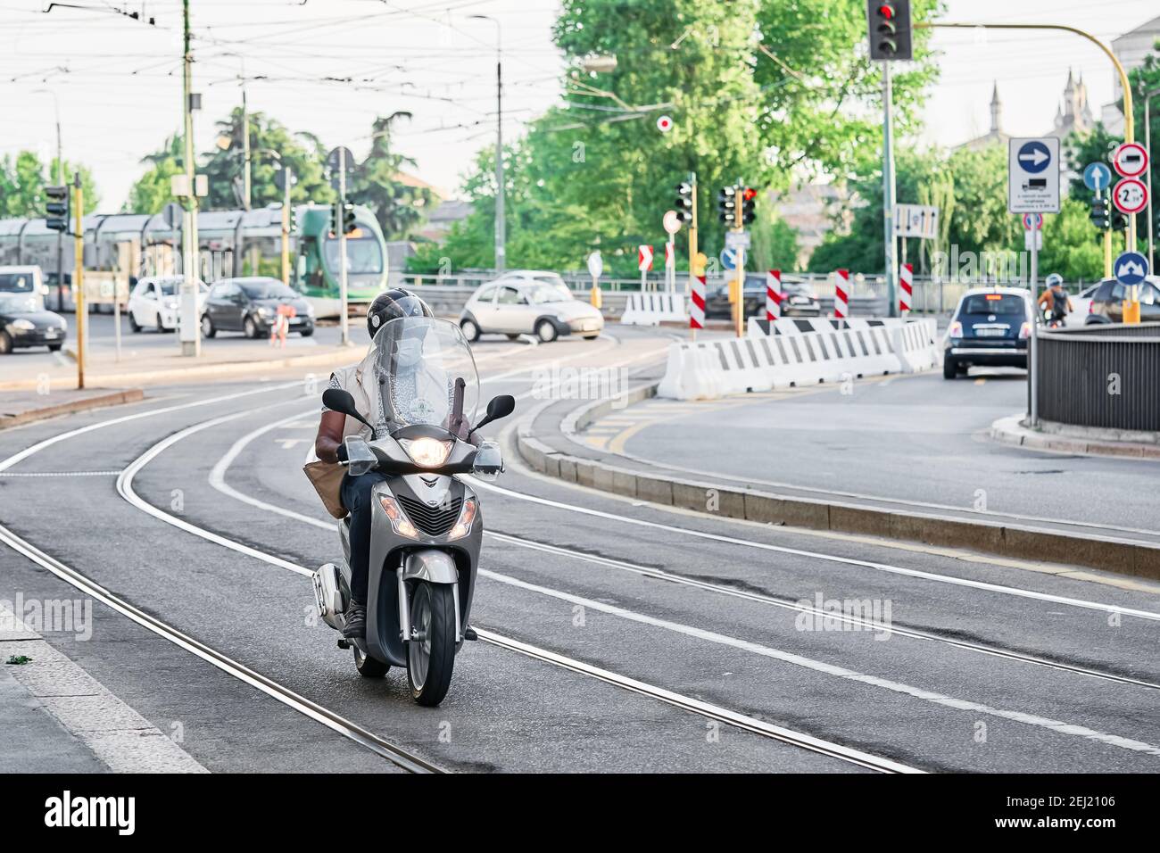 Man riding motorbike in busy city street traffic on tram track.  Motorcyclist drives motorcycle. Milan, Italy - May 26, 2020 Stock Photo -  Alamy