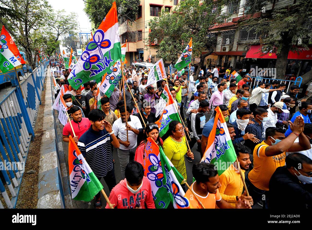 Protesters marching with flags during the demonstration.All India Trinamool Congress protest against the regular price hike on Petrol & Diesel in front of an Indian Oil Petrol Pump. Stock Photo