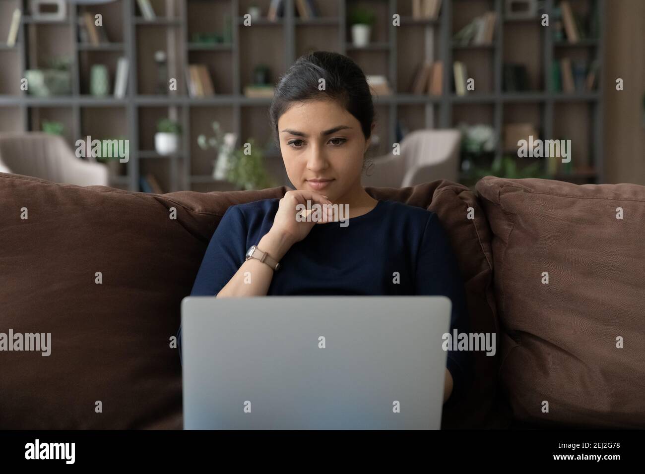 Pensive young Indian woman work on computer thinking Stock Photo - Alamy