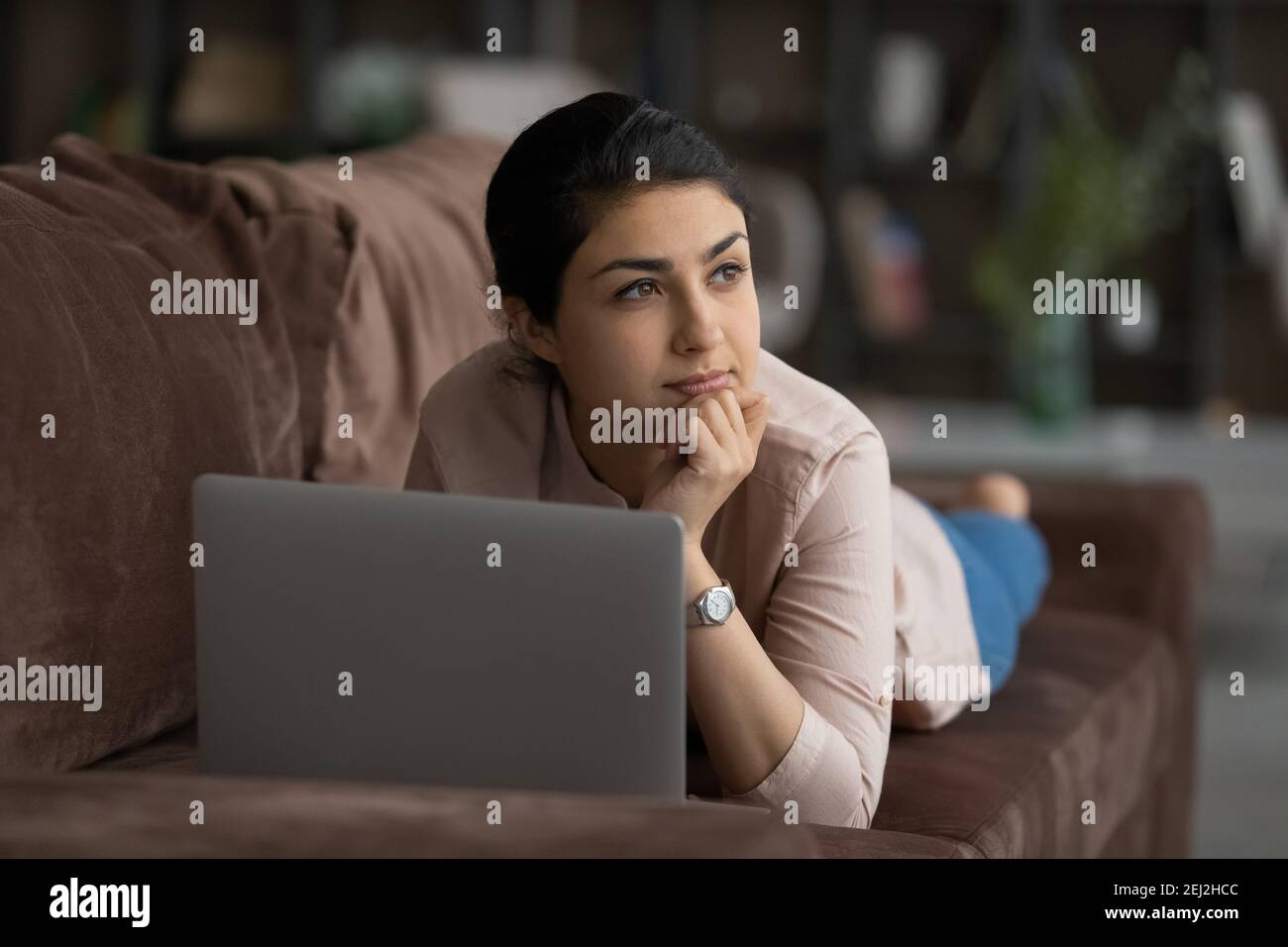 Pensive Indian woman relax on sofa dreaming Stock Photo - Alamy