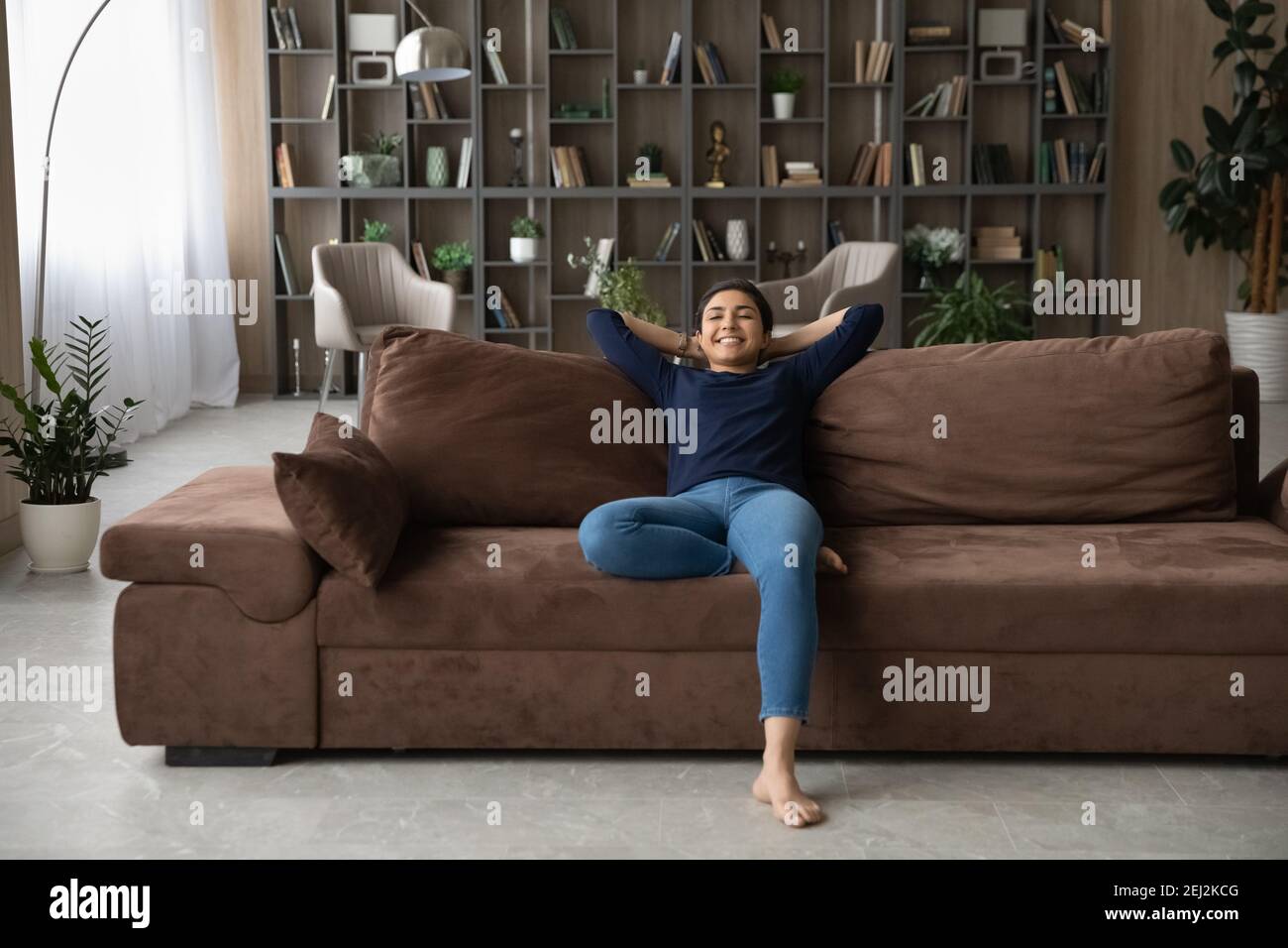 Happy Indian woman relax on sofa in modern home Stock Photo - Alamy