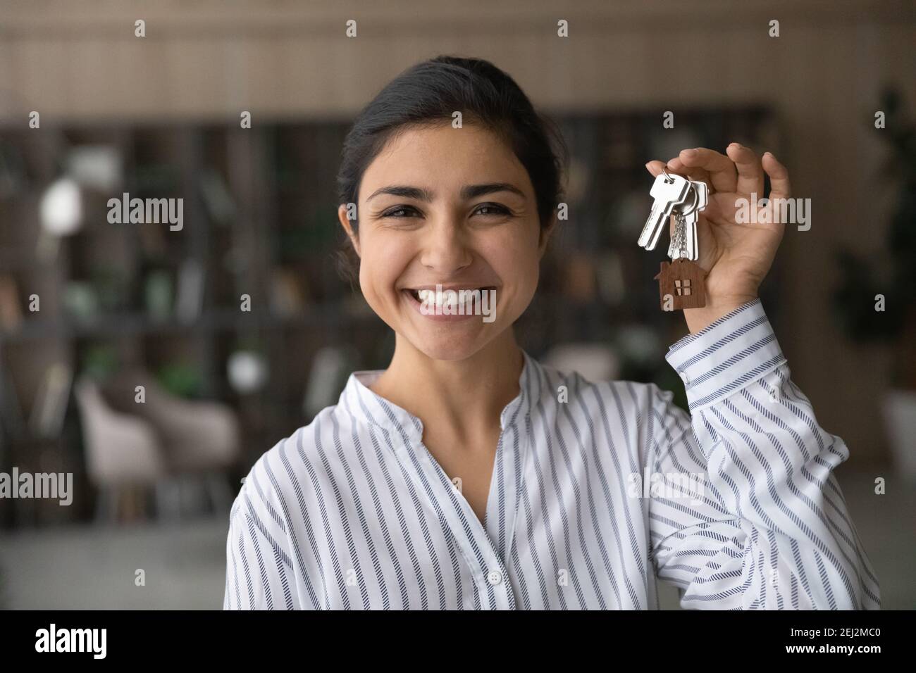 Portrait of smiling Indian woman show keys to new home Stock Photo - Alamy