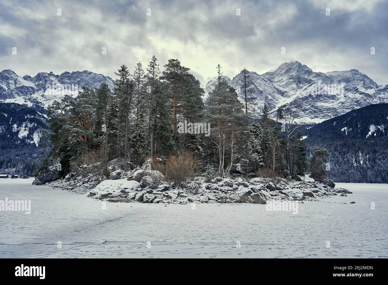 Island in Frozen Lake Eibsee with Zugspitze on Winter Day Stock Photo
