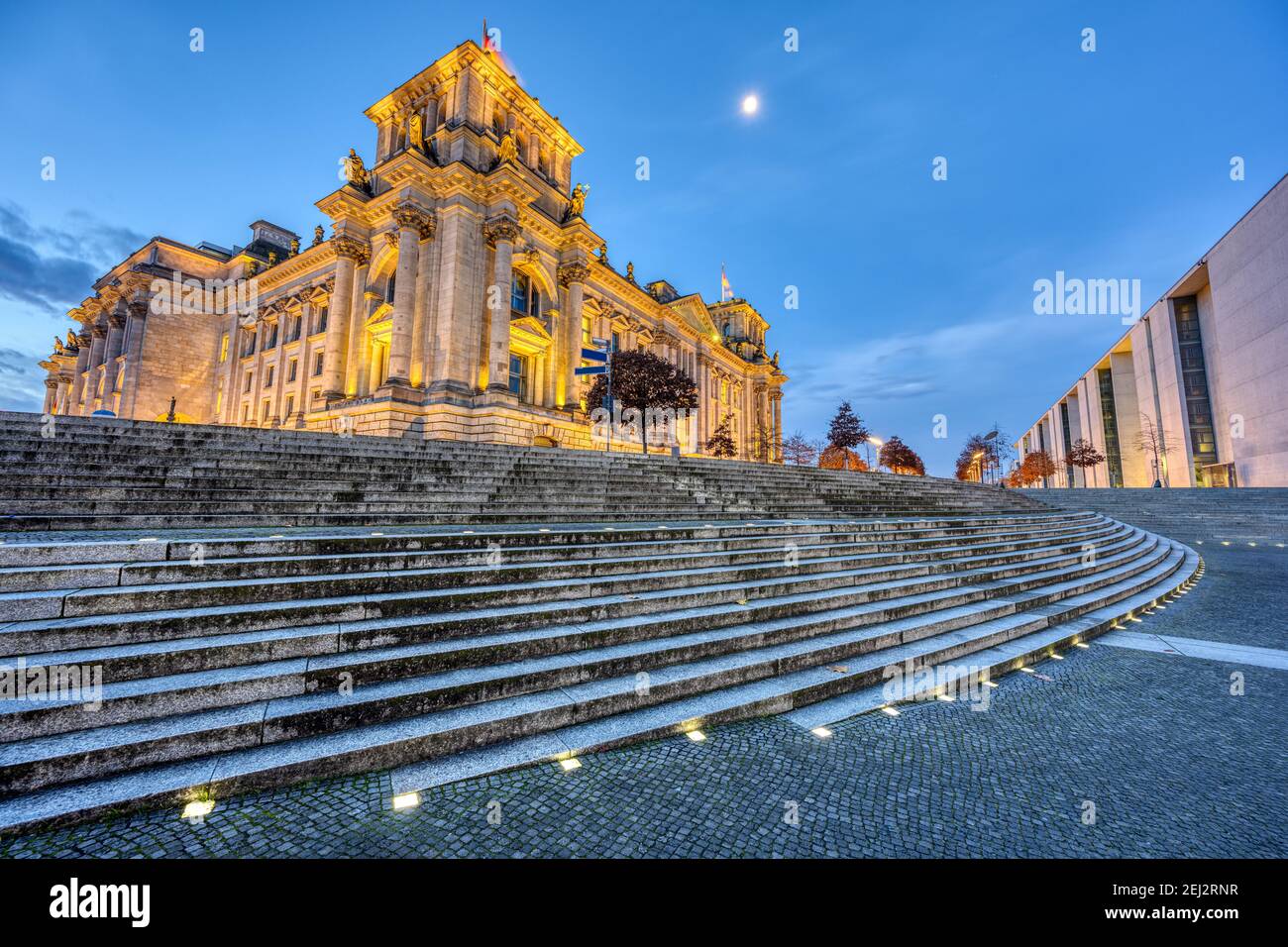 The illuminated Reichstag in Berlin seen from the river Spree at dawn Stock Photo