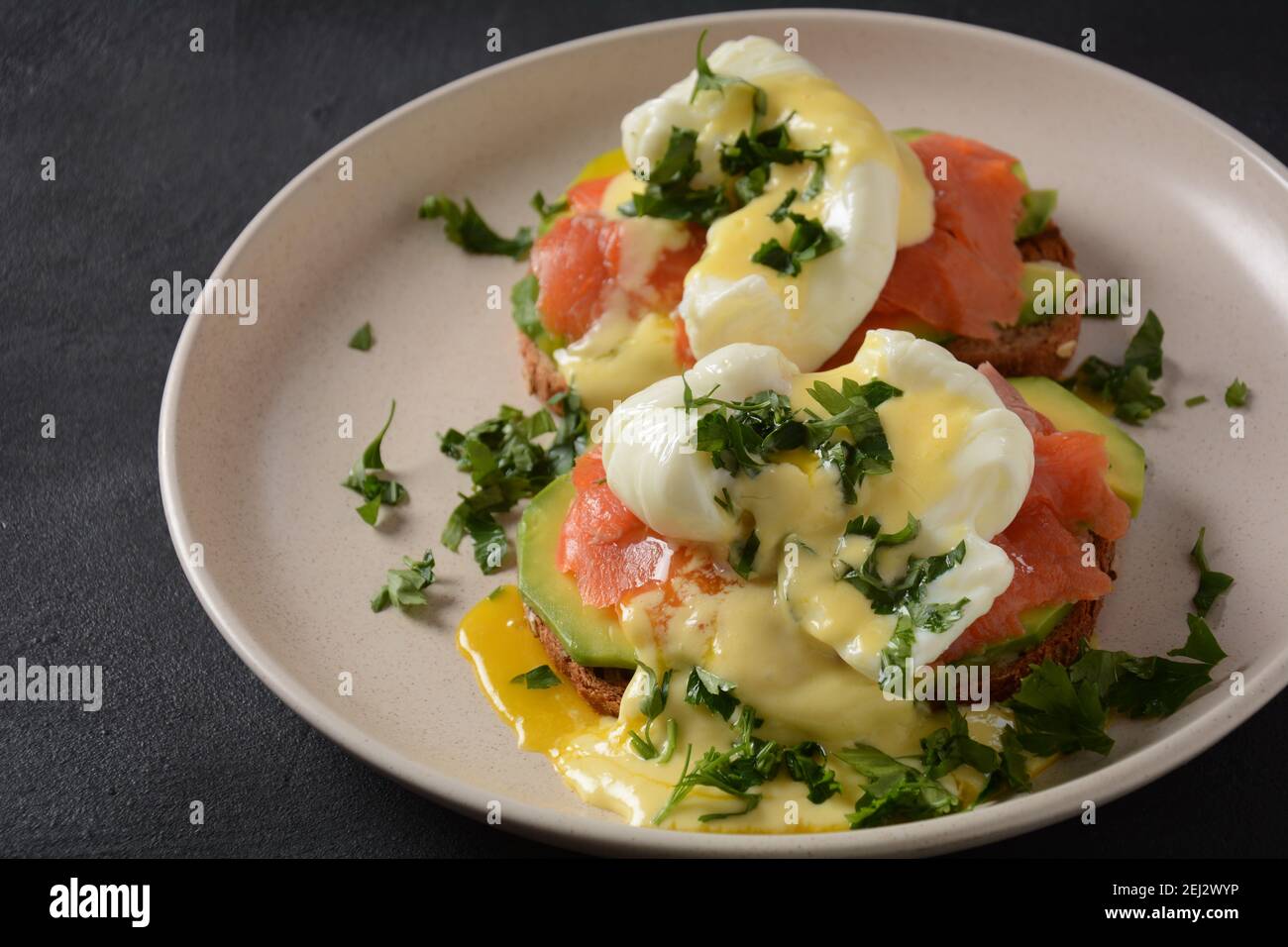Eggs Benedict with smoked salmon, avocado slices and hollandaise sauce